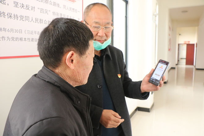 魏兴岭在向老党员展示学习强国成绩.jpg